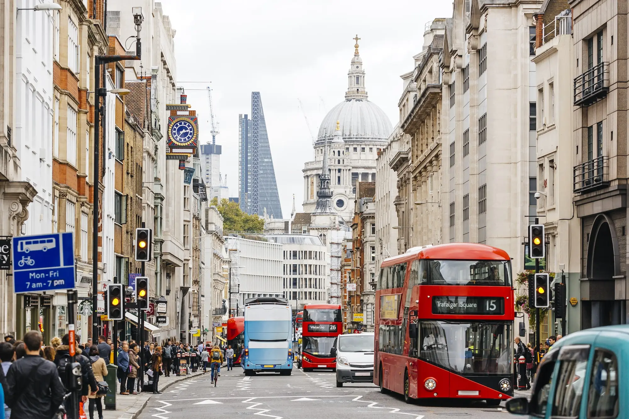 Photograph of the Shard building and a red tourist bus in London.